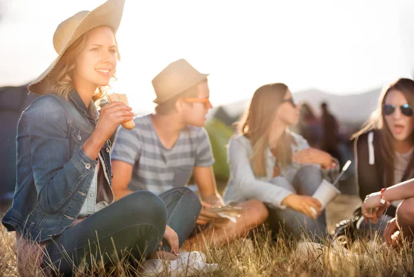 Adolescenti seduti a terra davanti alle tende, a mangiare — Foto Stock