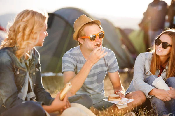 Tieners zittend op de grond voor tenten, rust — Stockfoto