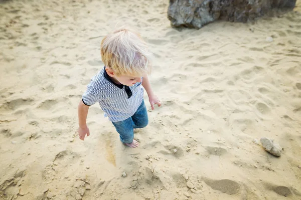 Blonder kleiner Junge spielt am Sandstrand. — Stockfoto