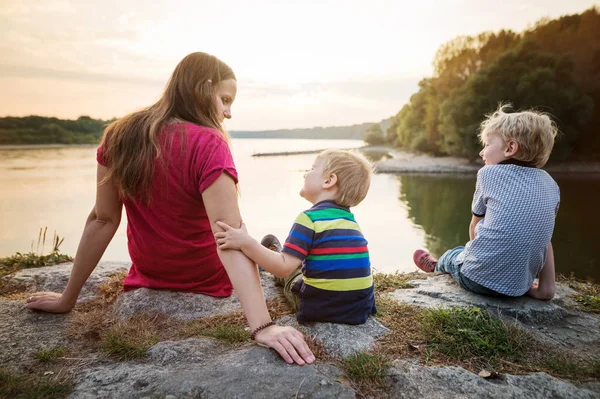 Mère avec deux fils au bord du lac, jour ensoleillé du printemps . — Photo