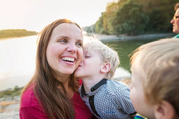 Mère avec deux fils au bord du lac, jour ensoleillé du printemps . — Photo