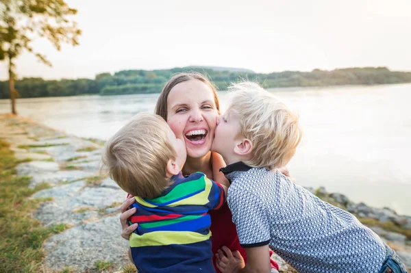 Mère avec deux fils au bord du lac, jour ensoleillé du printemps . — Photo