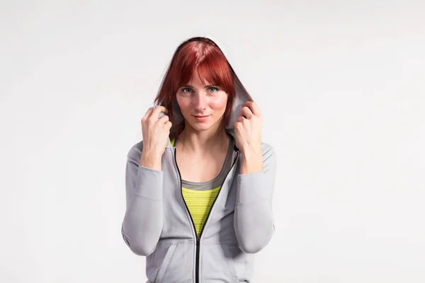 Attractive young fitness woman in gray sweatshirt. Studio shot. — Stock Photo, Image