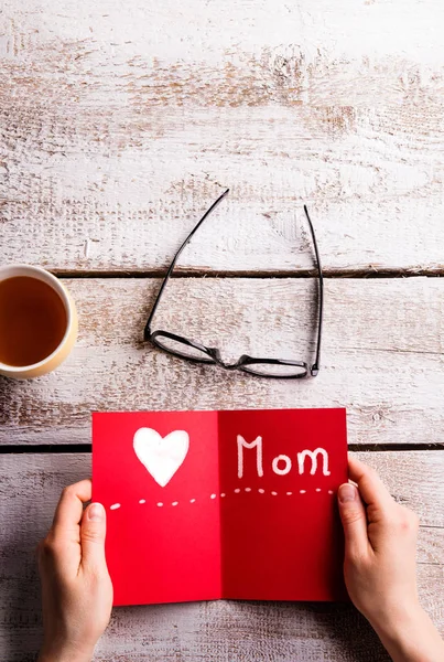 Onherkenbaar vrouw met rode wenskaart. Studio schoot. — Stockfoto