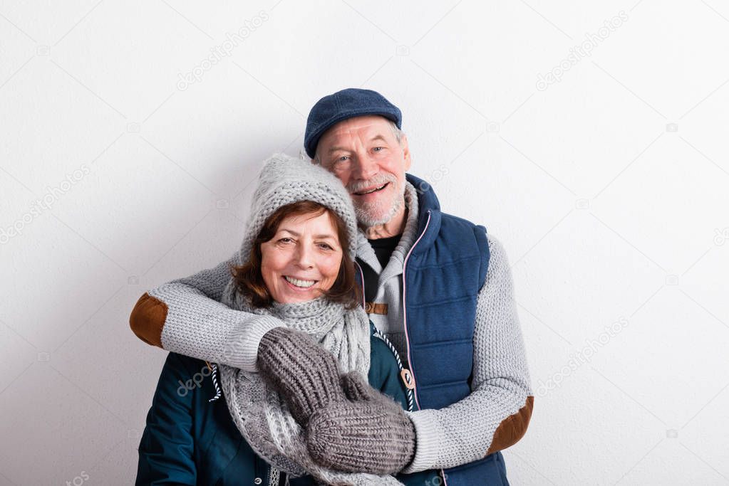 Beautiful senior couple in love in winter clothes. Studio shot.