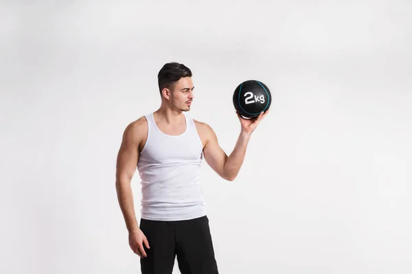 Handsome fitness man holding medicine ball, studio shot. — Stock Photo, Image