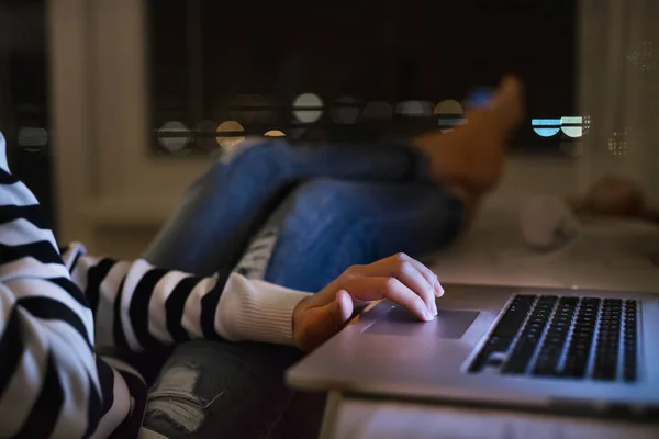 Неузнаваемая женщина сидит за столом и работает с ноутбуком . — стоковое фото