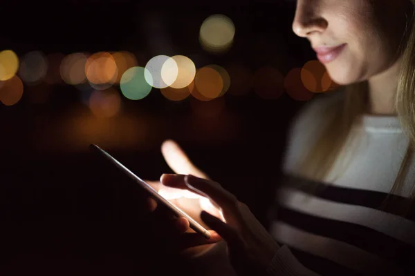 Unerkennbare Frau in der Nacht mit Smartphone, SMS. — Stockfoto