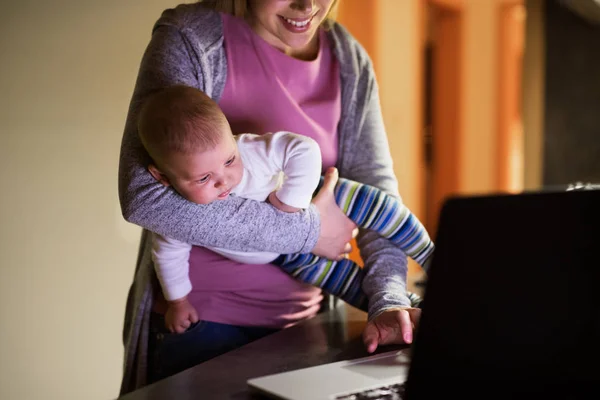 Unrecognizable mother with son, working on laptop — Stock Photo, Image