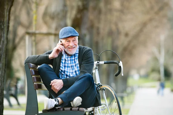 Homme âgé avec vélo et téléphone intelligent, passer un appel téléphonique — Photo