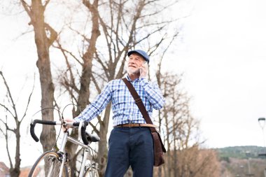 Üst düzey adam akıllı telefon ve şehirde bisiklet.