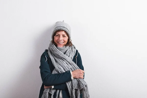 Senior woman in woolen scarf and hat, studio shot. — Stock Photo, Image