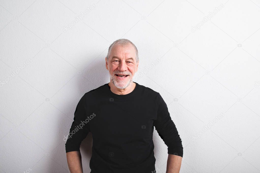 Senior man in black woolen sweater, studio shot.