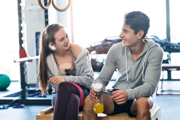 Красивая молодая пара в современном спортзале говорит . — стоковое фото