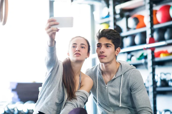 Fit casal no moderno ginásio crossfit com smartphone . — Fotografia de Stock