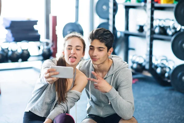 在现代的运动量来找到健身房与智能手机适合情侣. — 图库照片