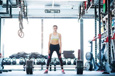 Güzel genç kadın ağır halter kaldırma spor salonunda yerleştirmek.