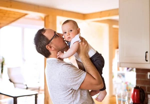 Young father holding his cute baby son in the arms — Stock Photo, Image