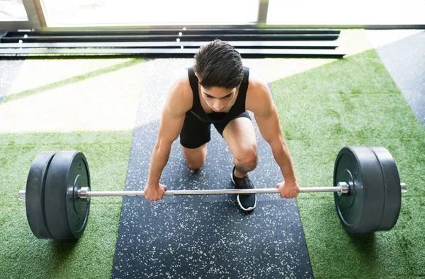 Genç İspanyol adam ağır halter kaldırma spor salonunda yerleştirmek. — Stok fotoğraf