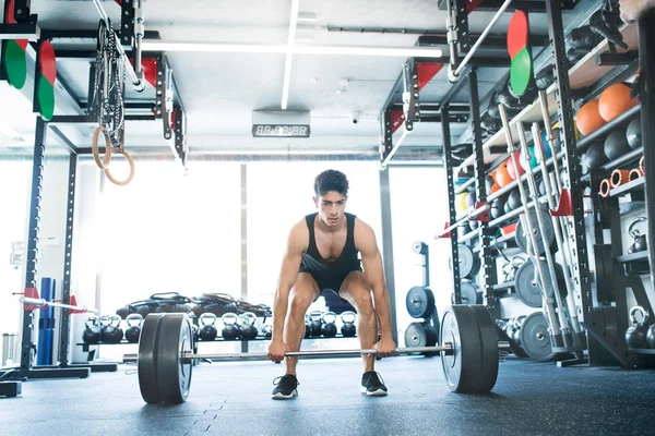 Ung träna spansktalande mannen i gymmet lyfta tung skivstång — Stockfoto