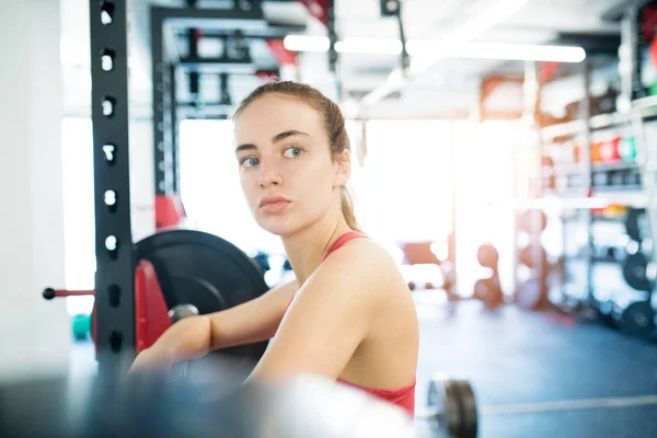 Giovane donna in palestra in piedi al pesante bilanciere — Foto Stock