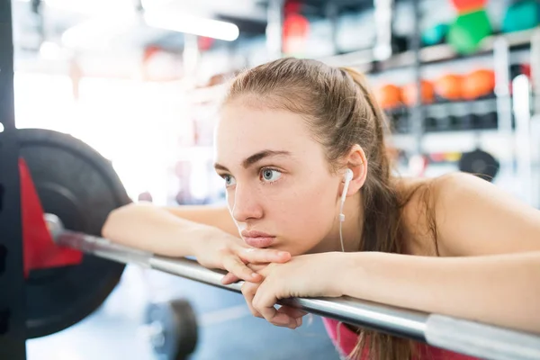 Junge Frau im Fitnessstudio, Kopfhörer in den Ohren, Musik hörend — Stockfoto