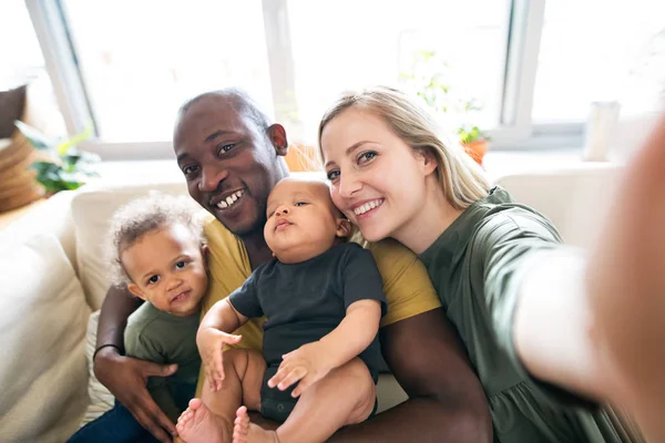 Joven familia interracial con niños pequeños tomando selfie . —  Fotos de Stock