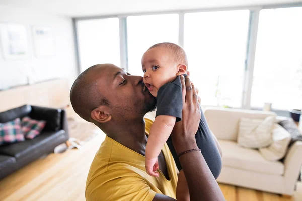 Joven padre afroamericano sosteniendo a su hijo en brazos —  Fotos de Stock