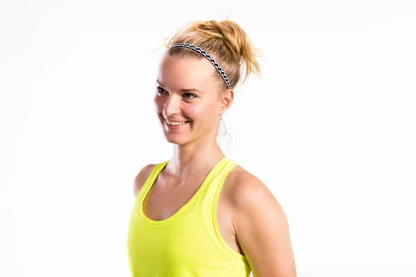 Aantrekkelijke jonge fitness vrouw in gele tank top. Studio schoot. — Stockfoto