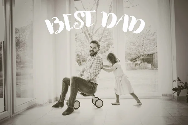 Father and daughter riding bike indoors. Fathers day concept.