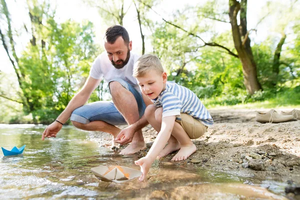 Padre joven con niño en el río, día soleado de primavera . — Foto de Stock