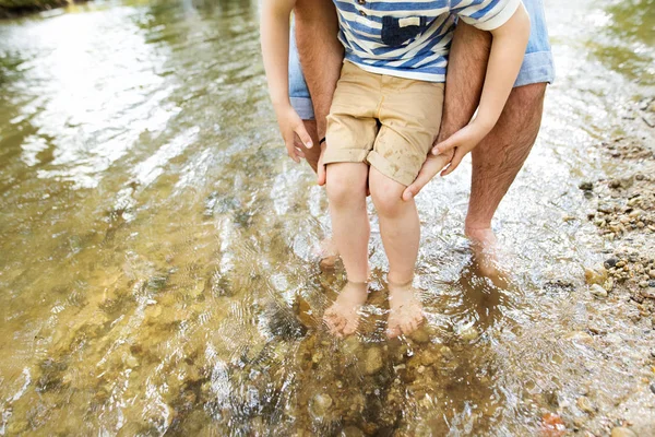Vater und Sohn unkenntlich im Fluss, sonniger Tag. — Stockfoto