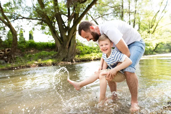 Unga far med liten pojke i floden, solig vårdag. — Stockfoto