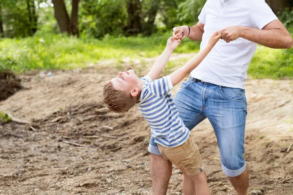 Unrecognizable father with little son in green woods, sunny day. — Stock Photo, Image