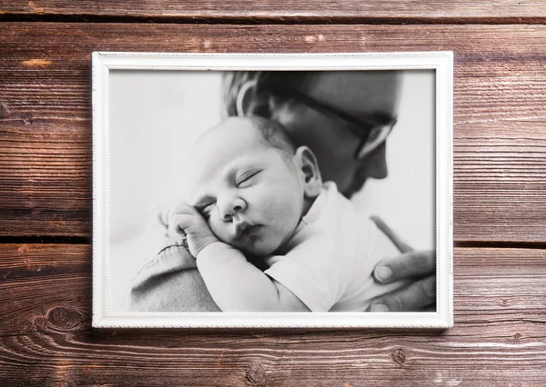 Foto do pai segurando seu bebê. Fundo de madeira . — Fotografia de Stock