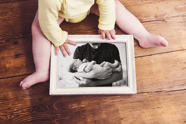 Unrecognizable baby holding picture frame. Fathers day.