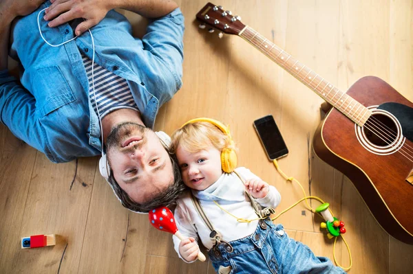 Padre e hijo con smartphone y auriculares, escuchando música . — Foto de Stock