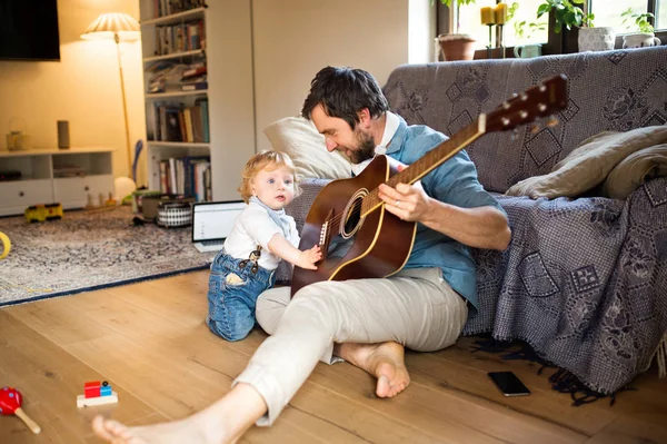 Baba ve oğul evde birlikte gitar çalmak. — Stok fotoğraf