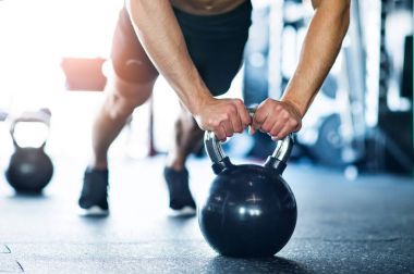 Tanınmayan uygun adam gönderme yapıyor spor salonunda ups kettlebells üzerinde