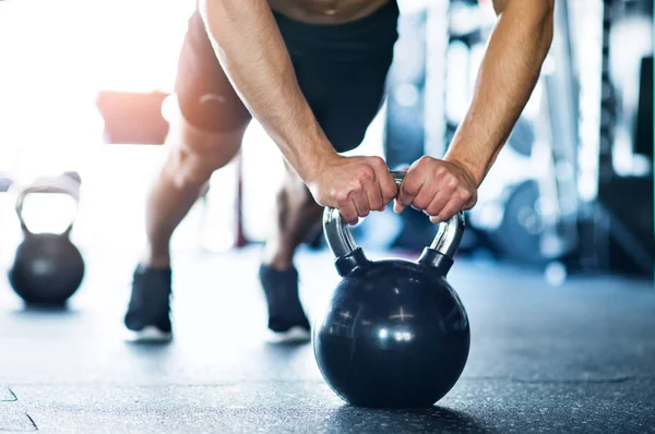 Onherkenbaar passen man in de sportschool doet push ups op kettlebells — Stockfoto