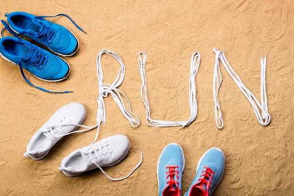 Běžecké boty a běhu znamení z tkaničky, písek — Stock fotografie