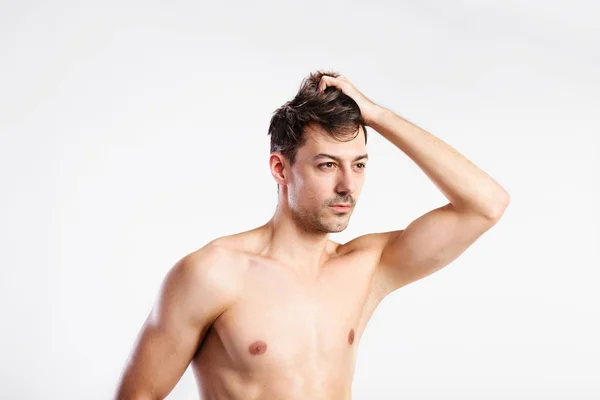 Hemdloser Fitness-Mann, der seine Haare hält. Studioaufnahme. — Stockfoto