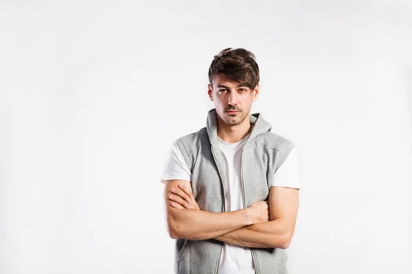 Handsome fitness man in vest with hood, studio shot. — Stock Photo, Image