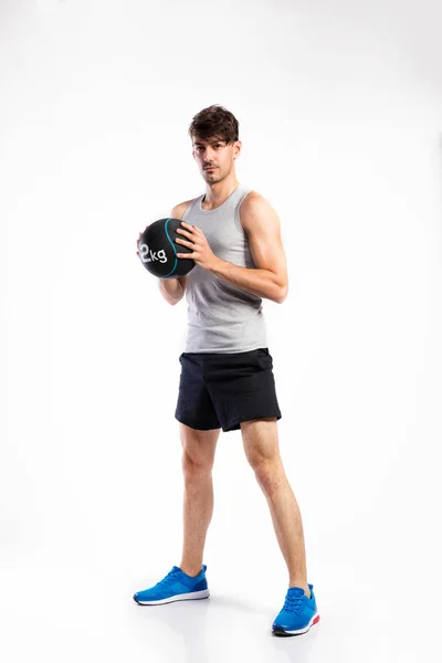 Schöner Fitnessmann mit Medizinball, Studioaufnahme. — Stockfoto