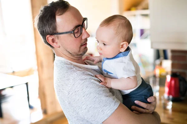 Jovem pai segurando seu filho bebê bonito nos braços — Fotografia de Stock