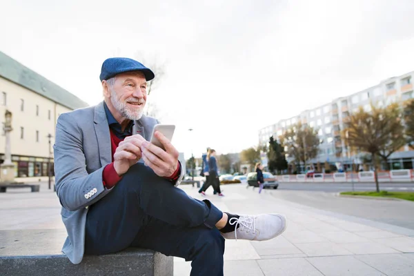 Hombre mayor en la ciudad con teléfono inteligente, mensajes de texto —  Fotos de Stock