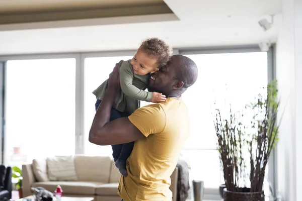 Joven padre afroamericano con su pequeña hija en casa . —  Fotos de Stock