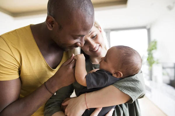 Joven madre con su hija pequeña y su padre afroamericano en casa . —  Fotos de Stock