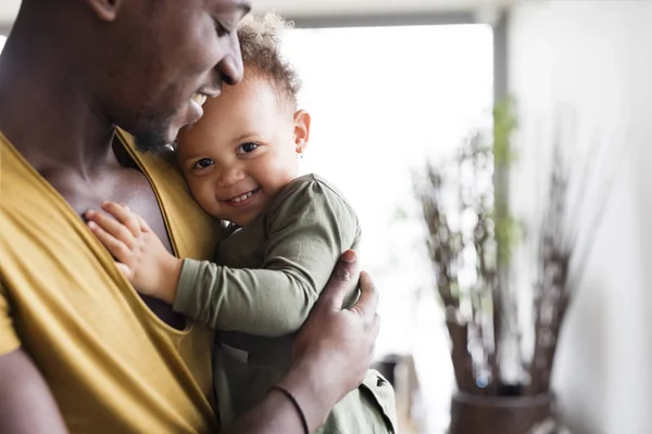 Joven padre afroamericano con su pequeña hija en casa . —  Fotos de Stock