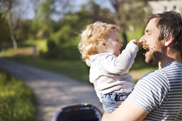 Vader met dochtertje zoon en baby in kinderwagen. Zonnige park. — Stockfoto